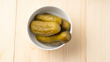 Pickled lightly salted cucumbers in white plate on wooden background, Lenten food in Great Lent of Christians