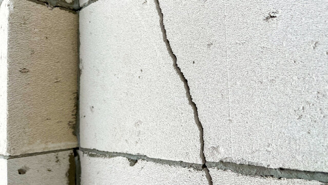 Corner of room with crack in wall, a crack in gas block wall, defective wall, cracked masonry, Cracks on wall, Low-quality brickwork, subsidence and cracking in wall