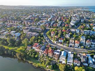 Aerial view of a picturesque residential neighborhood nestled alongside a serene body of water - Powered by Adobe