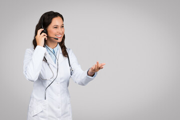 Telemedicine, e-health concept. Cheerful european female doctor with headset and stethoscope have video call with patient