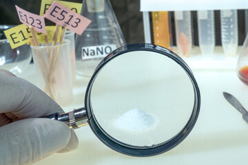 A laboratory technician examines a white powder. Food additives, medicinal powder, antibiotic....
