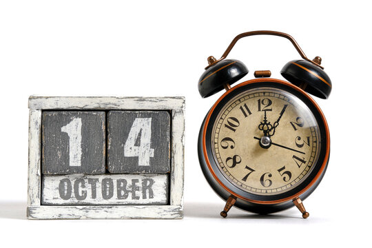 October 14 on wooden calendar with alarm clock white background.