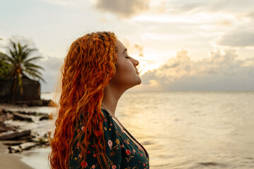 Young hispanic woman breathing fresh air at sunset