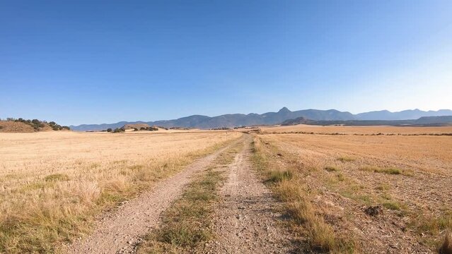 Camino Catalan de Santiago - Camino de Bolea dirt road with a view to the pre-Pyrenees mountain range after Chimillas, Hoya de Huesca, Aragon, Spain