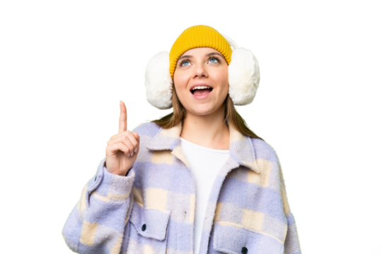 Young blonde woman wearing winter muffs over isolated chroma key background pointing up and surprised