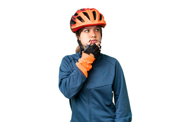 Young cyclist girl over isolated chroma key background having doubts and with confuse face expression