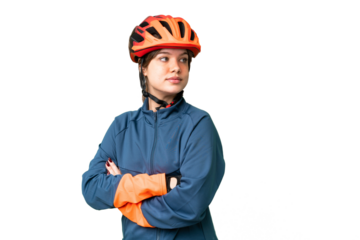 Young cyclist girl over isolated chroma key background with arms crossed and happy