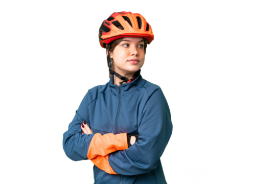 Young cyclist girl over isolated chroma key background with arms crossed and happy