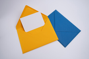 Paper yellow and blue envelopes on a light background. New mail, write a message. Send and receive mail. Postal delivery service. Empty envelope, empty space. Envelope close-up 