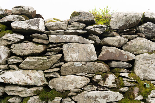 Close up of dry stone wall near an archaeological site in southern Ireland in a light gray tone and with a texture that demonstrates its great age