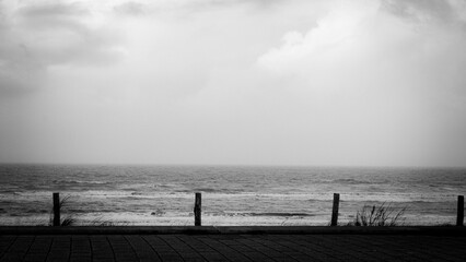 Schwarz weiß Foto mit Zaun am Meer