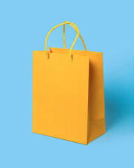 Yellow paper shopping bag on blue background. Shopping sale delivery concept. Packaging gift.