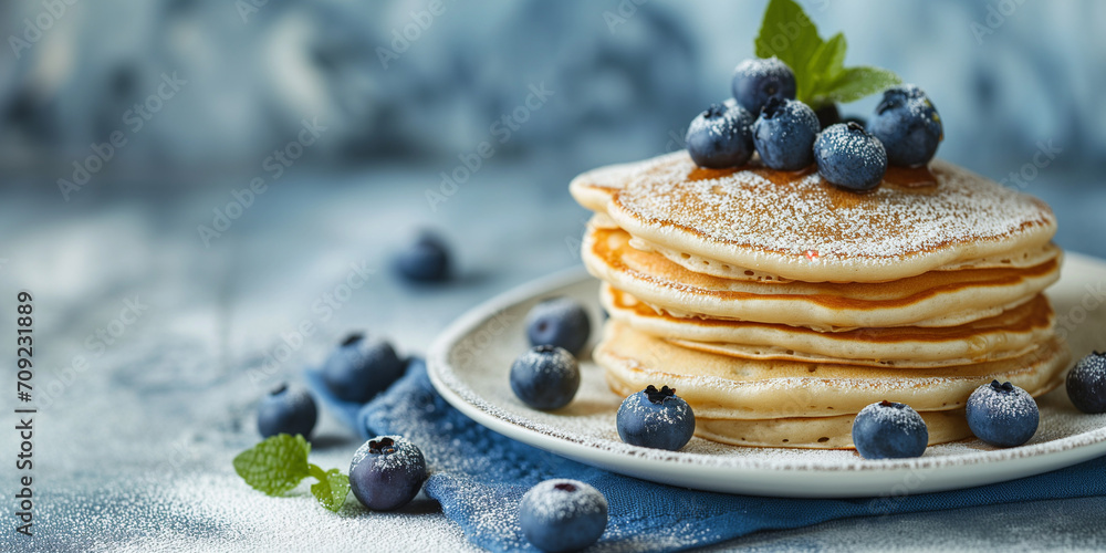 Wall mural fluffy tasty pancakes with blueberries on a plate in bright daylight. rustic shabby chic feel. panca