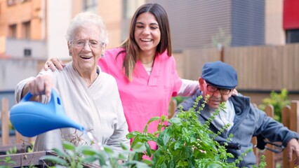Nurse and senior people watering plants outdoors a nursing home