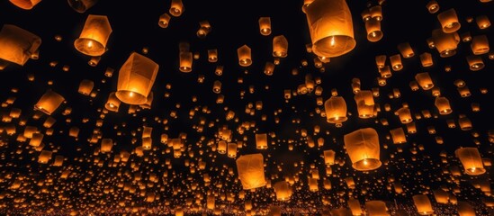 Chinese sky lanterns floating in a dark night sky