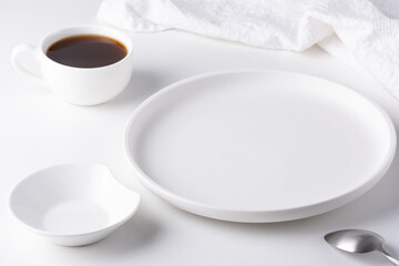 Cup of coffee and empty white plate