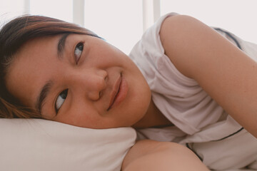 Fototapeta na wymiar Close up of lazy Asian woman just wake up but not going to get up from the bed.