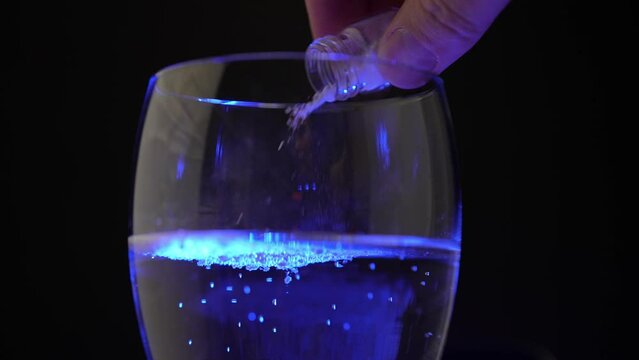 Club cocktail in the disco party get drugged. Putting drugs in drink at the bar. Strange unknown medicine powder falling down in glass with adult drink. Drink spiking.
