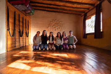 Group portrait of a community of people practicing yoga smiling and looking at the camera.