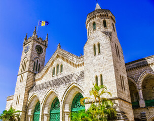 Fototapeta na wymiar Parliament Building, Clock Tower and Flag in Bridgetown, Barbados during a beautiful summer day