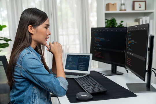 Young Asian IT developer looking online information on pc for beautiful pose with coding program data of website application, wearing jeans shirt. surround by safety analysis two screens. Stratagem.