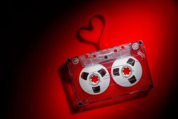 Valentines day background - audio cassette with heart shaped tape in red light