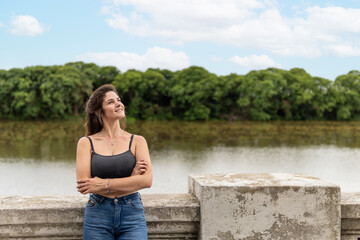 Portrait of young woman enjoying the day posing on the waterfront