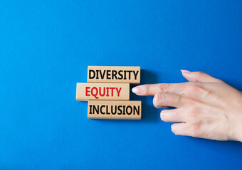 Diversity Equity Inclusion symbol. Concept words Diversity Equity Inclusion on wooden blocks. Beautiful blue background. Businessman hand. Business and Diversity Equity Inclusion concept. Copy space