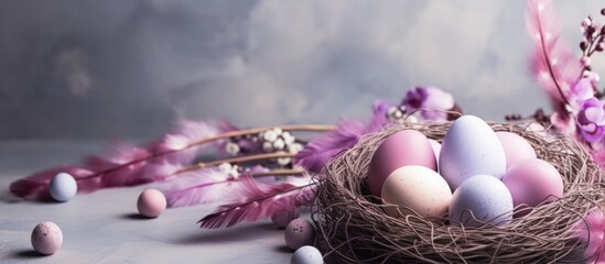 Easter eggs in a nest with purple feathers and flowers on a gray background.