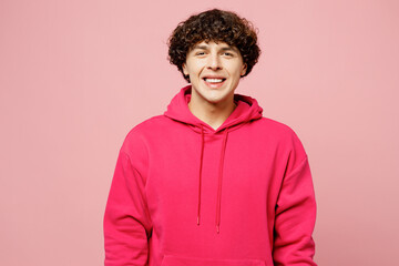 Obraz na płótnie Canvas Young smiling happy cheerful satisfied friendly Caucasian man he wears hoody casual clothes looking camera isolated on plain pastel light pink color wall background studio portrait. Lifestyle concept.