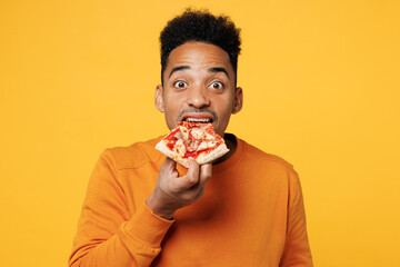 Young man he wear orange sweatshirt casual clothes hold eating slice of italian pizza isolated on...