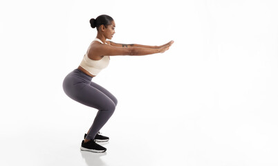Black Fitness Woman Doing Squat Exercise Over White Studio Background