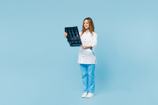 Full body female doctor woman wears medical gown suit work in hospital clinic office hold x-ray brain by radiographic image ct scan mri isolated on plain blue background. Health care medicine concept.