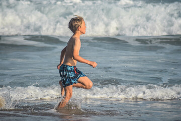 Fototapeta premium boy running in water, knysna, south africa