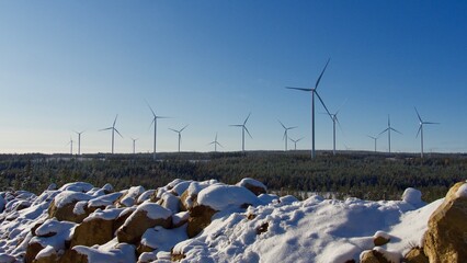 A group of wind turbines at a wind farm on a hill, creating renewable energy in Sweden