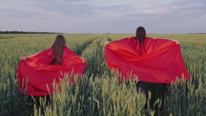 Teenage girls dream of becoming superheroes. Slow motion. Girls-children run in red raincoats....