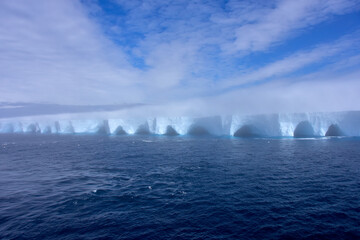 Fog surrounding an iceberg floating in Antarctica.