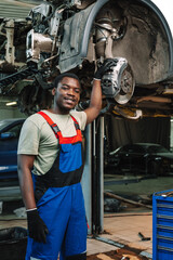 Fototapeta na wymiar Portrait of young african man car service worker wearing uniform standing in garage