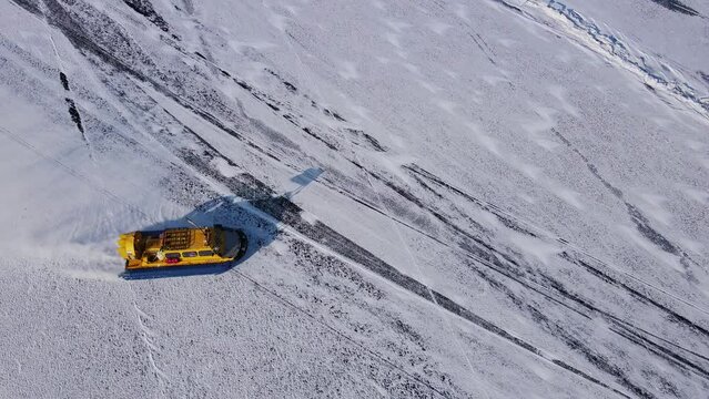 Hovercraft glides over Baikal's ice northern nature's marvel Hovercraft unusual mode transport ice. Hovercraft on lake facing snow frost extreme north Extreme travel exploring icy terrains.