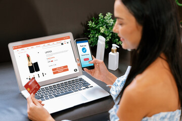 Young woman order or purchase product on internet using laptop and make transaction payment by...