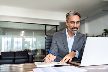 Middle-age Hispanic man using laptop computer for business studying, watch online virtual webinar...