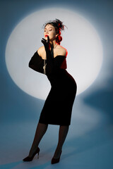 An elegant young woman in retro-style clothes poses in full height. - 709285288