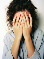 a woman hiding her face behind her hands 