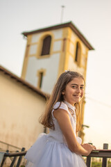 Smiling girl happily celebrating her first communion in a natural and sunny environment