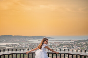 Fototapeta na wymiar Smiling girl happily celebrating her first communion in a natural and sunny environment
