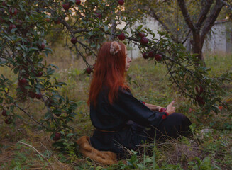 Selfie portraits of a red-haired woman with a fluffy tail and ears in the summer outdoors in an...