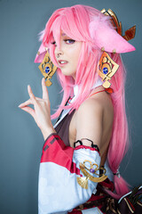 Female cosplayer in a pink anime costume wearing pink hair