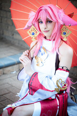 Female cosplayer in a pink anime costume wearing pink hair