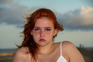 Naklejka premium Young woman on the beach with windblown hair