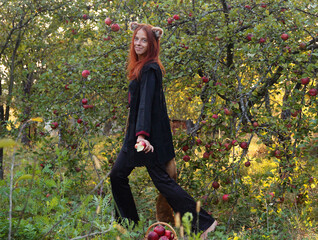 Selfie portraits of a red-haired woman with a fluffy tail and ears in the summer outdoors in an...